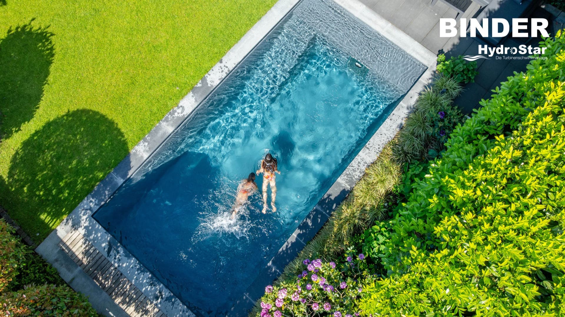 Aerial view of a swimmer in a sunlit pool with an EasyStar counter-current system, bright blue water on a sunny day